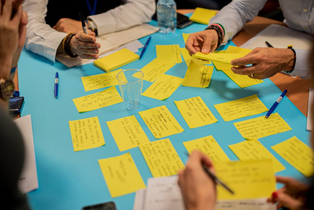 Leute die Post Its beschriften und sortieren